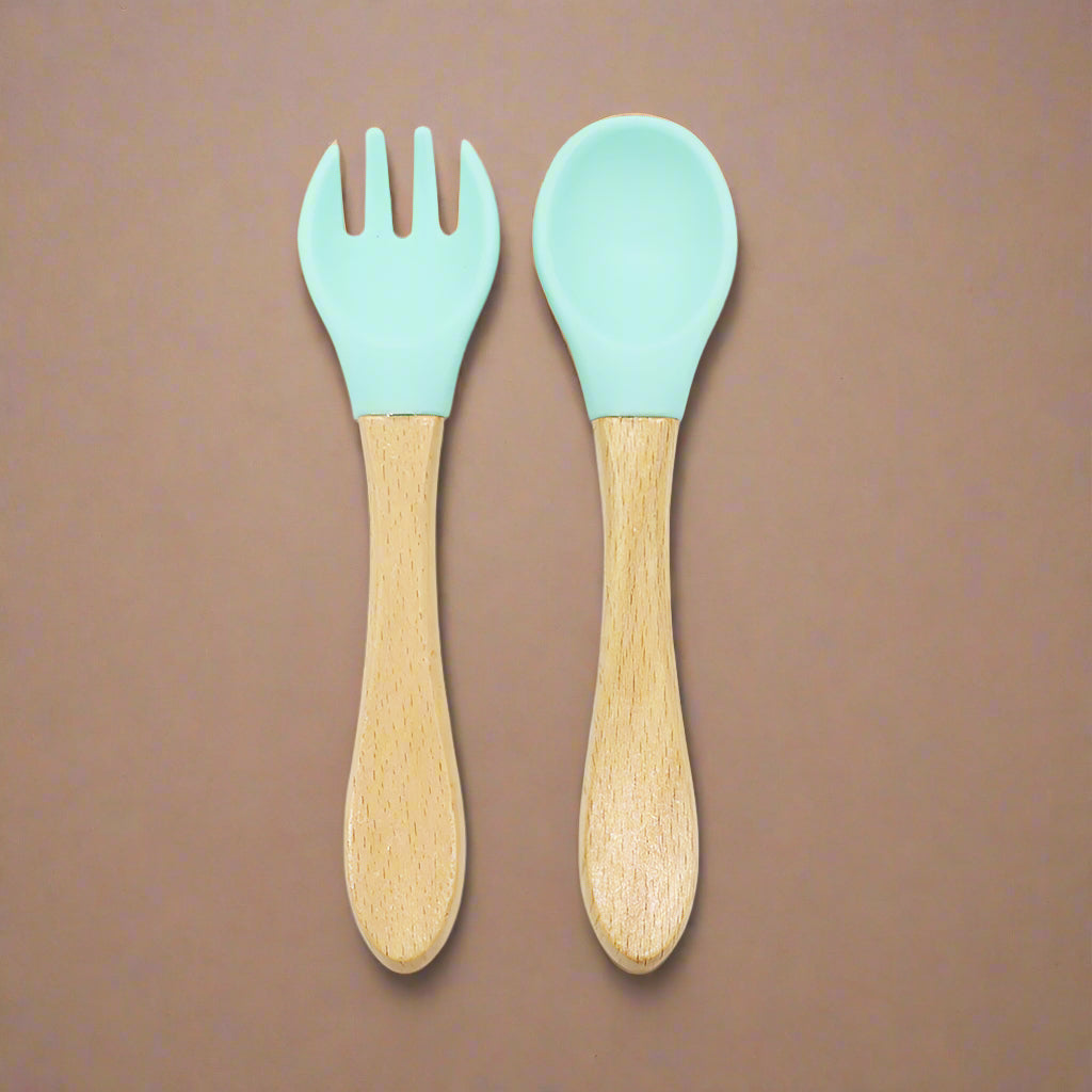 Ergonomic baby training fork and spoon set designed for self-feeding. BPA-free, non-toxic, and perfect for baby-led weaning and toddler meals.